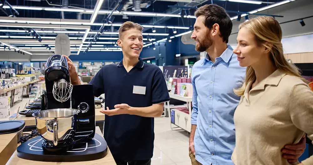 salesman-presents-kitchen-appliance-to-couple-in trade marketing retail, tecnologia masivo